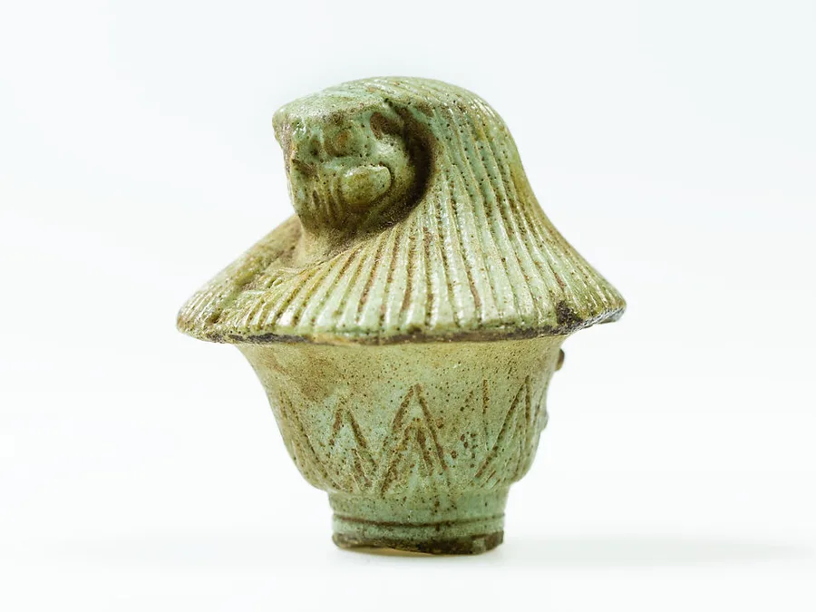 Small Egyptian faience papyrus-scepter amulet top with a falcon head.